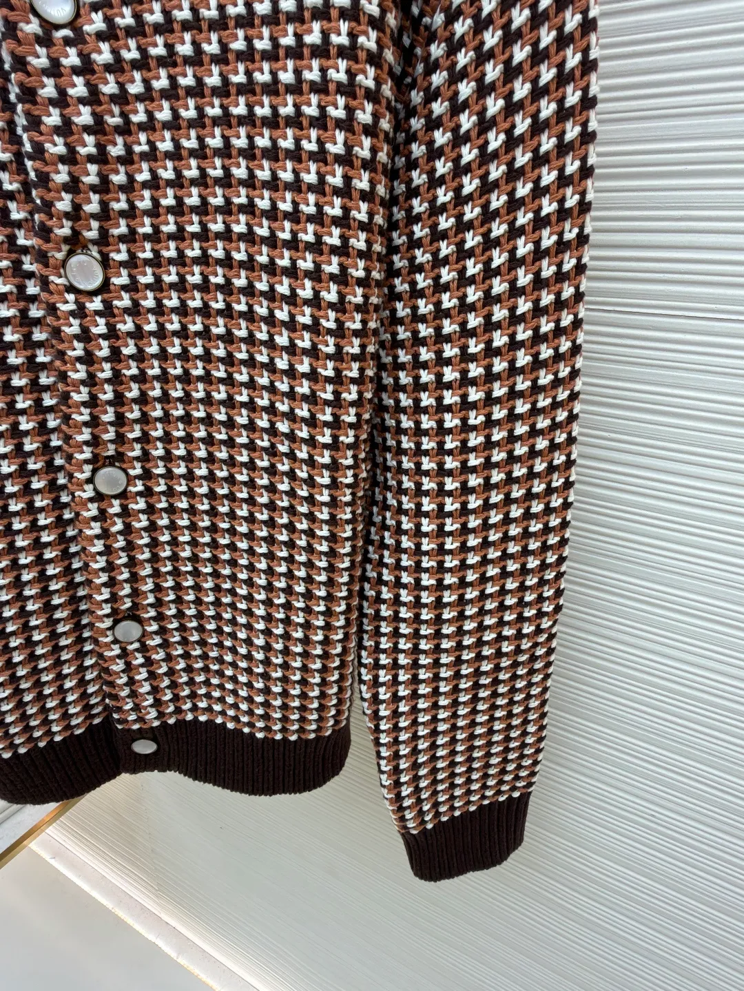 LOUIS VUITTON Thick needle houndstooth color block jacquard pearl button knitted cardigan ●Item number: 1682237-B95 ●Material: wool blended fabric ●Technology: knitted jacquard production ●Color: pattern ●Version: fitted version ●Weight: about 1220 grams ●Size: S-M-L-XL ●Description: This houndstooth knitted cardigan is woven with worsted wool blended yarn. It uses double-ply threading technology to make the yarn tighter. It uses yarn-dyed jacquard technology to create a classic houndstooth pattern. The pattern is clear and symmetrical, with natural color transitions and is not easy to fade. The body of the garment uses a four-knit knitting process. The fabric has high density, good elasticity, and good warmth retention and anti-pilling properties. The neckline, cuffs and hem are designed with ribbed edges and are made of high-elastic spandex blended ribs, which will not easily loosen and deform after long-term wear. The placket is equipped with matte mother-of-pearl buttons, which are hand-polished and polished for a warm texture. The overall design adopts three-dimensional tailoring, and the stitching between the shoulders and body uses embedded clip technology. The stitching is smooth and has no bulges. The spacing of each stitch is precisely controlled, and the exquisite knitting craftsmanship and ingenuity are displayed in every detail. The overall wiring is straight and delicate, the fabric is comfortable and soft, and the color is consistent without color difference. It can be matched with the same style to create a fashionable look and control various occasions. Customized accessories, complete with three standards, same style for men and women!